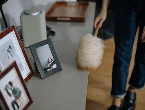 Astma a alergie: Skutečný důvod, proč vaše děti doma kašlou 6 A woman using a feather duster to clean picture frames on shelves indoors